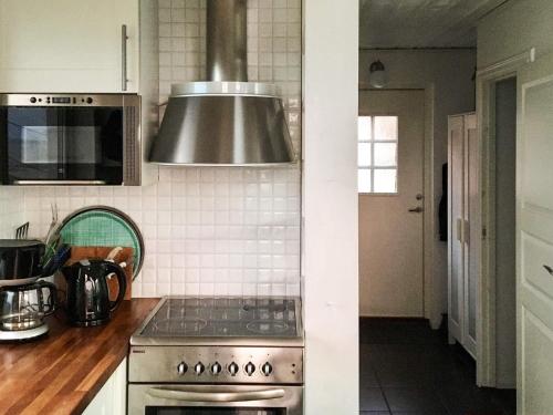 a kitchen with a stove and a microwave at 4 star holiday home in BRäNNö in Brännö
