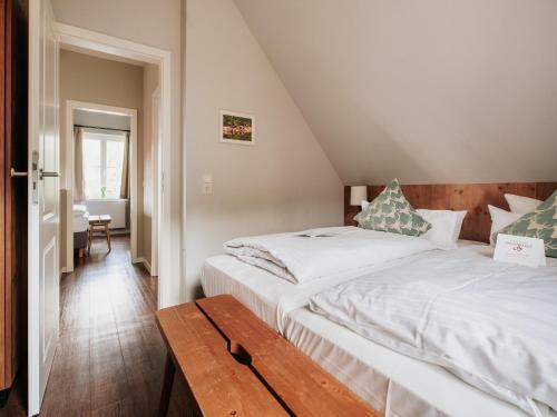 a bedroom with two white beds and a wooden bench at Ferienhaus in Schierke for 6 Personen in Schierke