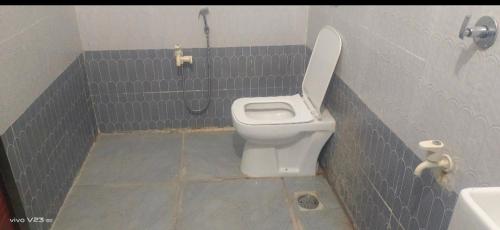 ein Bad mit einem WC in einer grauen Kabine in der Unterkunft Sea Bird Holiday Home Behind Revdanda High school in Alībāg