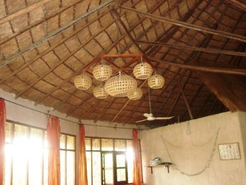a room with three chandeliers hanging from a wooden ceiling at LA Réserve Grande maison Cap Skirring avec piscine in Cap Skirring