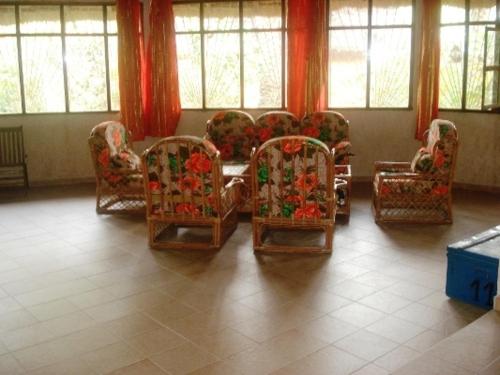 a room with chairs and a table and windows at LA Réserve Grande maison Cap Skirring avec piscine in Cap Skirring