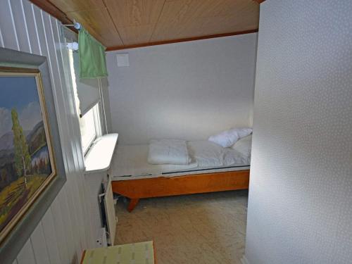 a small bed in a small room with a window at Summer cottage near the beach in Mellbystrand