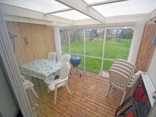 a screened in porch with a table and chairs at Summer cottage near the beach in Mellbystrand