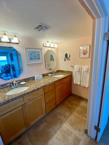 a bathroom with a sink and a mirror at Oceanfront 3-BR Condo with Large Beachfront Terrace in Dog City