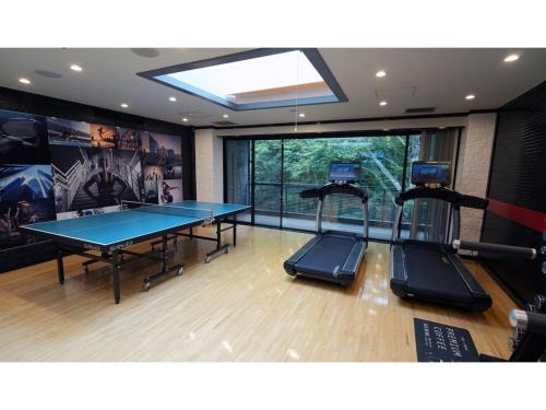 Una mesa de ping pong en una habitación con gimnasio. en YAMANO RESORT HOTEL EIGHE - Vacation STAY 20059v, en Shiozawa