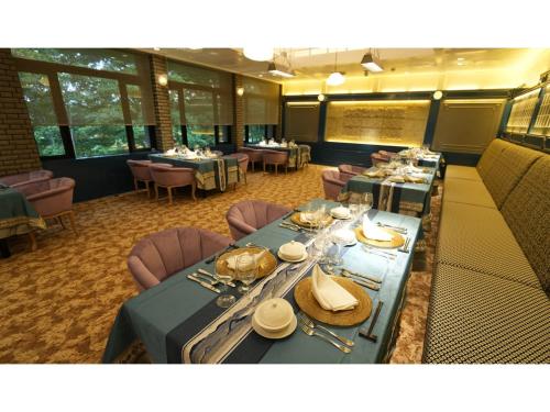 un comedor con mesas largas, sillas y mesa en YAMANO RESORT HOTEL EIGHE - Vacation STAY 20059v, en Shiozawa