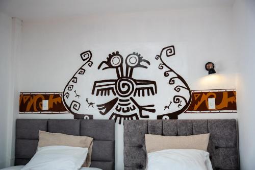 a black and white painting on the wall above a bed at Casa Antade Cusco in Cusco