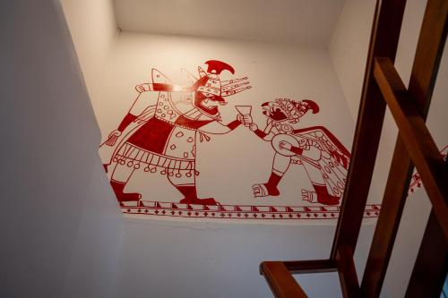 a painting of a man and a woman on a wall at Casa Antade Cusco in Cusco