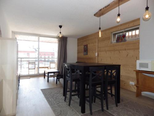 - une cuisine avec une table et des chaises noires dans la chambre dans l'établissement Les Deux Alpes - Appartement rénové pour 6, balcon exposé sud - FR-1-546-19, à Les Deux Alpes
