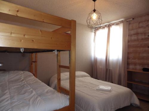 une chambre avec deux lits superposés et une fenêtre dans l'établissement Les Deux Alpes - Appartement rénové pour 6, balcon exposé sud - FR-1-546-19, à Les Deux Alpes