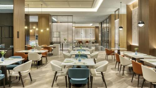 a restaurant with tables and chairs and a cafeteria at Holiday Inn Express Rugao City Center, an IHG Hotel in Nantong
