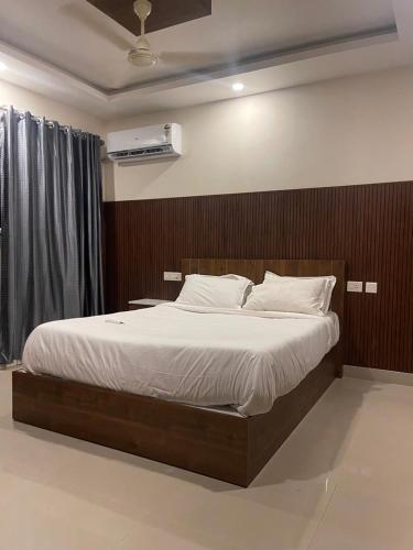 a bedroom with a large bed with a wooden headboard at VVP Rooms in Cochin