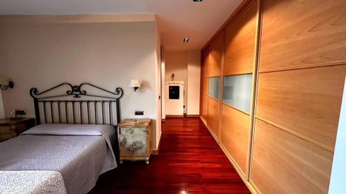 a bedroom with a bed and a wooden wall at Casa en Salamanca in Carbajosa de la Sagrada