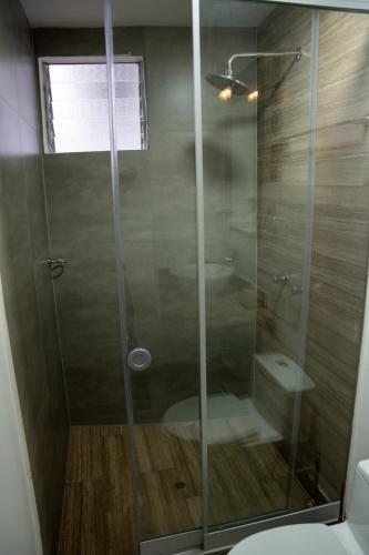 a glass shower in a bathroom with a toilet at Casa Antade Cusco in Cusco