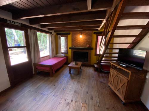 a living room with a couch and a fireplace at Complejo de Cabañas Tunquelen in Mar de las Pampas