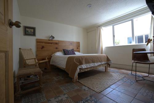 a bedroom with a bed and a window and a chair at Alojamiento Ideal Junto al Aeropuerto CDMX in Mexico City
