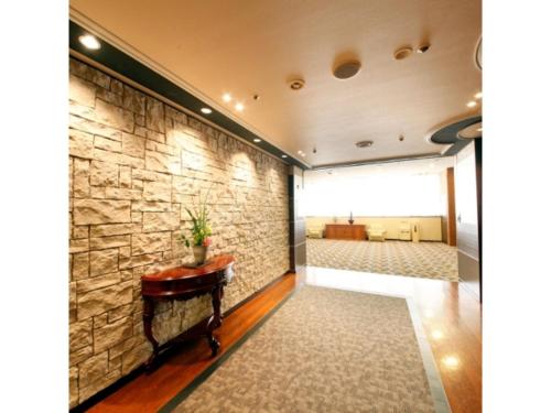 a room with a stone wall and a table at Central Hotel - Vacation STAY 99766v in Kusugaurachō