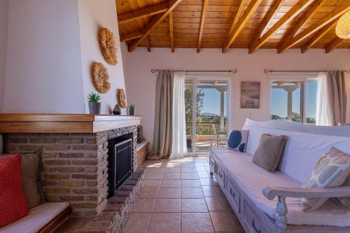 a living room with a couch and a fireplace at Sea View Villa-Luxury Residence-Nature & Calm Porto Heli in Porto Heli
