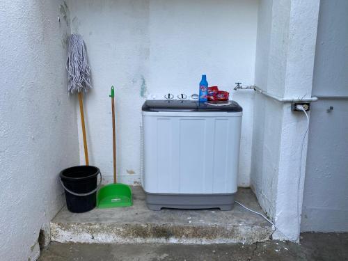 a small washing machine sitting next to a wall at Alojamiento el Reloj primer nivel in San Fernando de Monte Cristi