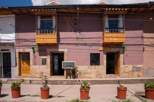 a pink building with flowers in front of it at Casa Antade Cusco in Cusco