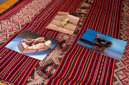a table topped with pictures ofartifacts on a rug at Casa Antade Cusco in Cusco
