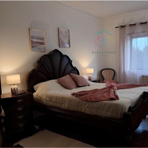 a bedroom with a bed and two lamps and a window at Mary's House in Cantanhede