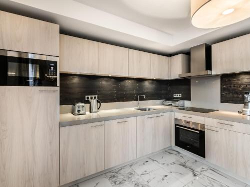 une cuisine avec des armoires en bois et un évier dans l'établissement Appartement 5 pièces, centre Courchevel Village, proche pistes, 8 pers., parking, fitness - FR-1-562-7, à Courchevel