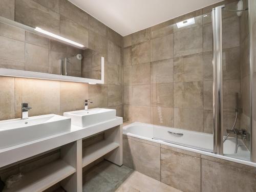 a bathroom with two sinks and a bath tub at Appartement moderne au cœur de Courchevel, proche pistes et commerces, 1 chambre, parking inclus - FR-1-562-16 in Courchevel