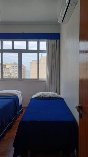 a bedroom with two beds and a window at Apartamento de Férias Copacabana Rio de Janeiro in Rio de Janeiro