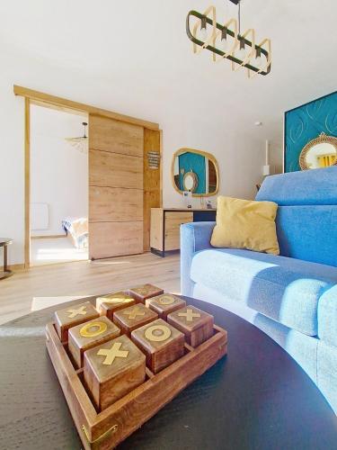 un salon avec un canapé bleu et une table dans l'établissement La Bresse Nature and Glisse, à La Bresse