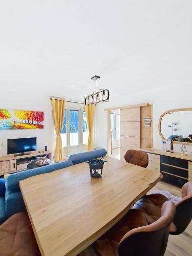 - un salon avec une table en bois et un canapé bleu dans l'établissement La Bresse Nature and Glisse, à La Bresse