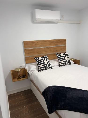 a bedroom with a bed with a wooden headboard at Apartamento Manzana in Seville