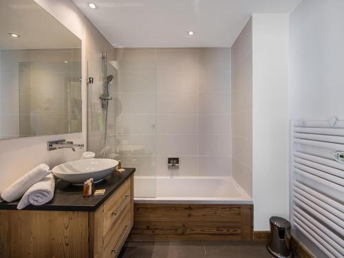 クールシュヴェルにあるChalet 5 étoiles près des pistes avec jacuzzi et sauna - FR-1-562-11の洗面台と浴槽のあるバスルーム
