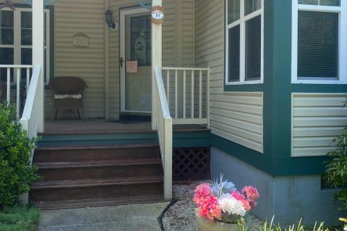 a front porch of a house with a door and flowers at Savannahs Landing --- 10 Mary Elizabeth Dr in Ocean View