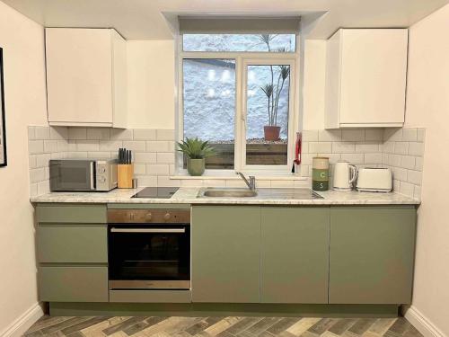 トーキーにあるStylish Studio Apartment on Torquay Harbourside!のシンクと電子レンジ付きのキッチン