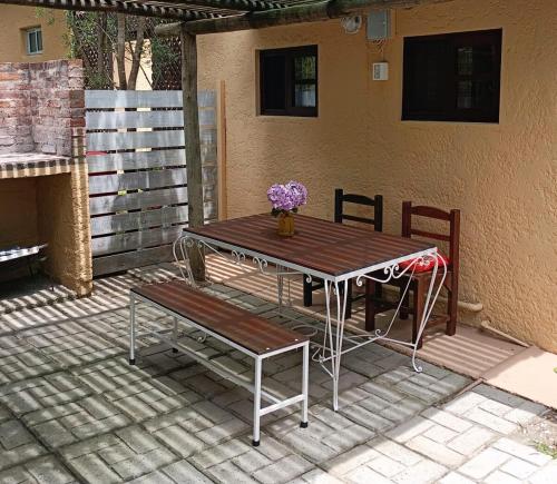 un tavolo in legno e una panca su un patio di El Dormilon 2 a La Pedrera