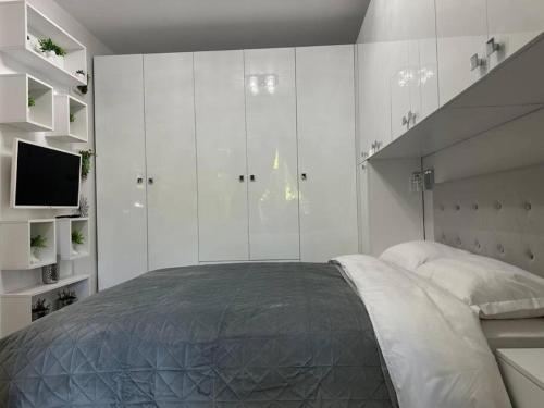 a bedroom with a large bed and white cabinets at Verdana apartament in Timişoara