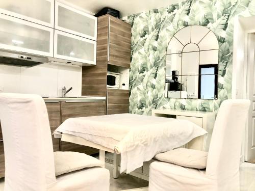 Cette chambre comprend une table, deux chaises et un miroir. dans l'établissement Apart Privé Parisien LA CASITA avec cuisine équipe -St charles - Near beaugrenelle -Tour Eiffel 75015 PARIS Bel emplacement !!, à Paris