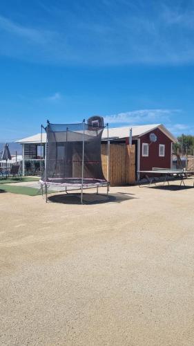 a batting cage in a dirt field with a building at Hospedaje vista hermosa in Quillota