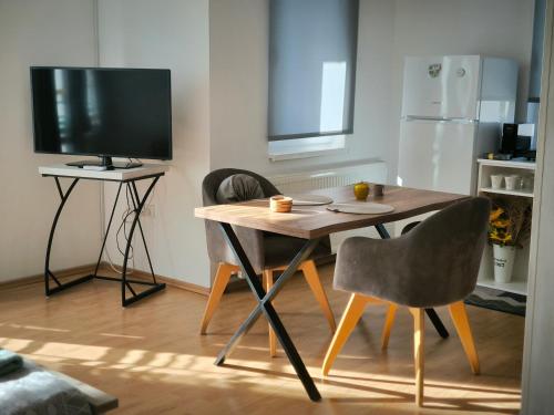 a kitchen with a table and two chairs and a television at Smestaj Dzentlmen in Soko Banja
