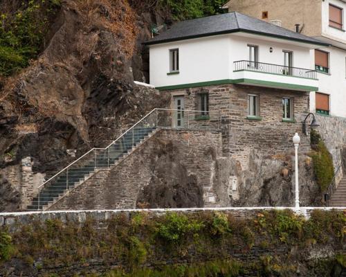 una casa al lado de una montaña en La Casa De Luarca, en Luarca