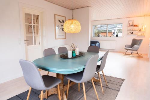 a dining room with a blue table and chairs at Villa Holstebro in Holstebro