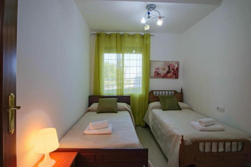 two twin beds in a room with a window at SpainKarmaSun in Torrox Costa