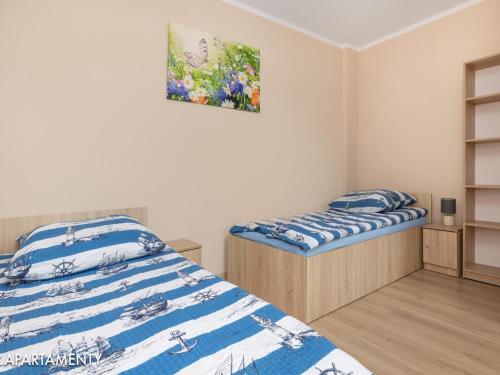 sypialnia z 2 łóżkami i obrazem na ścianie w obiekcie 2-level holiday apartments, Niechorze w mieście Niechorze