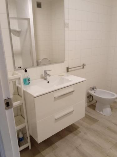 a white bathroom with a sink and a toilet at Paseo de noia in Noya