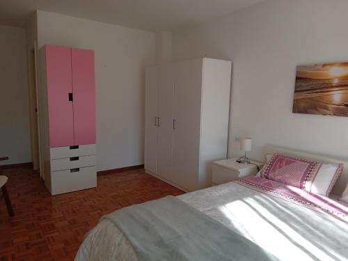 a bedroom with a bed and a pink cabinet at Paseo de noia in Noya