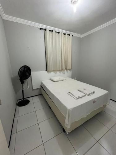 Camera bianca con letto e ventilatore. di Seller House a Sobral