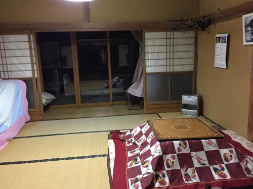 a room with a room with a bed and a room with windows at Ichinokurasou in Hakuba