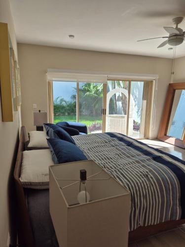 a bedroom with a bed with blue pillows and a window at Casa Victoria Cozumel in Cozumel