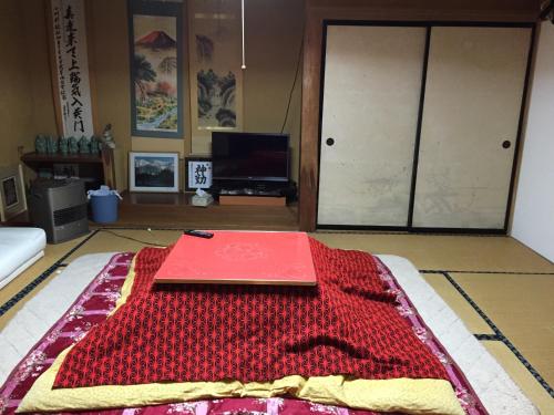 a red book sitting on top of a rug on the floor at Ichinokurasou in Hakuba